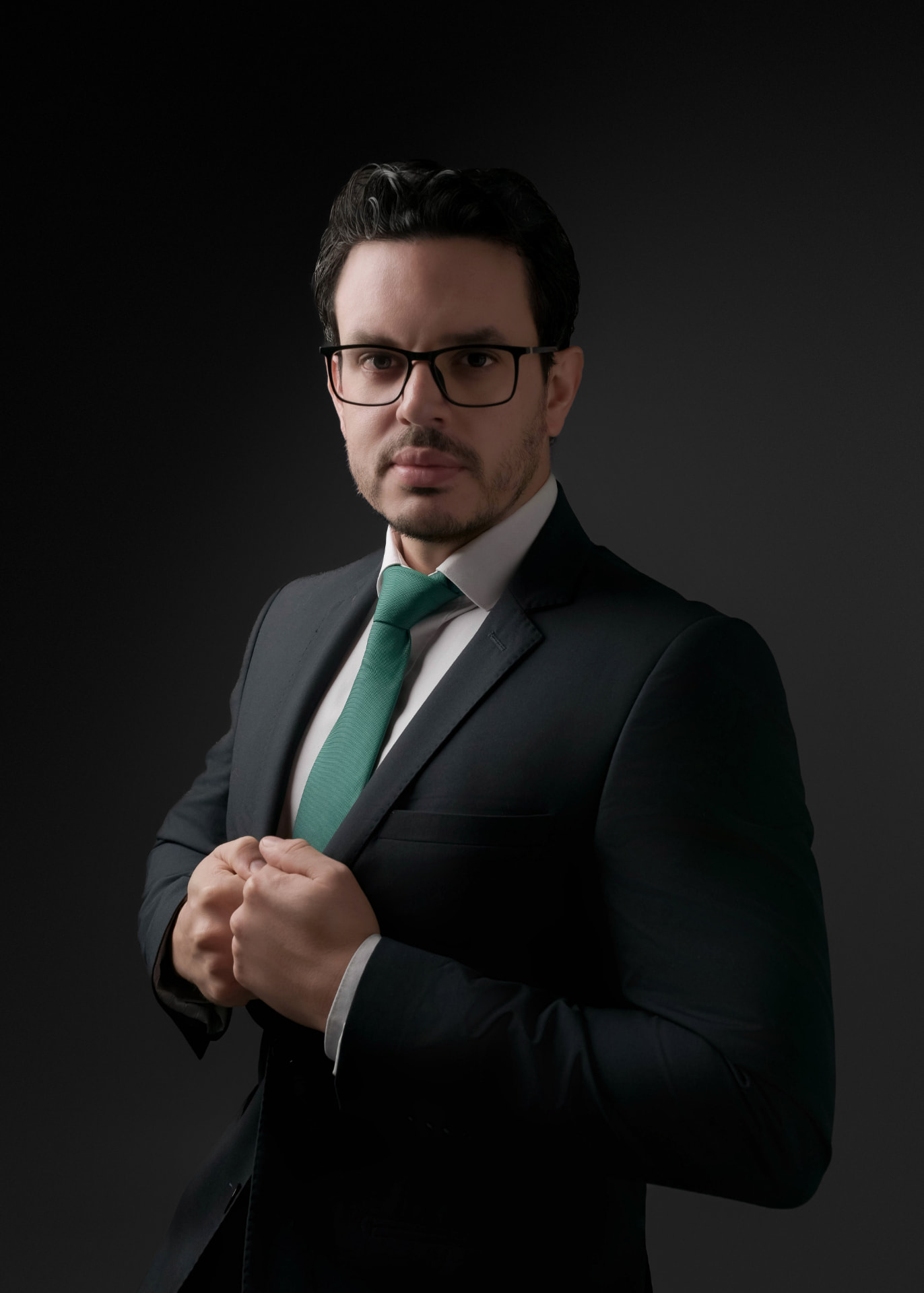 Adriano Barreto, planejador financeiro CFP®, ajustando o paletó em retrato de estúdio.